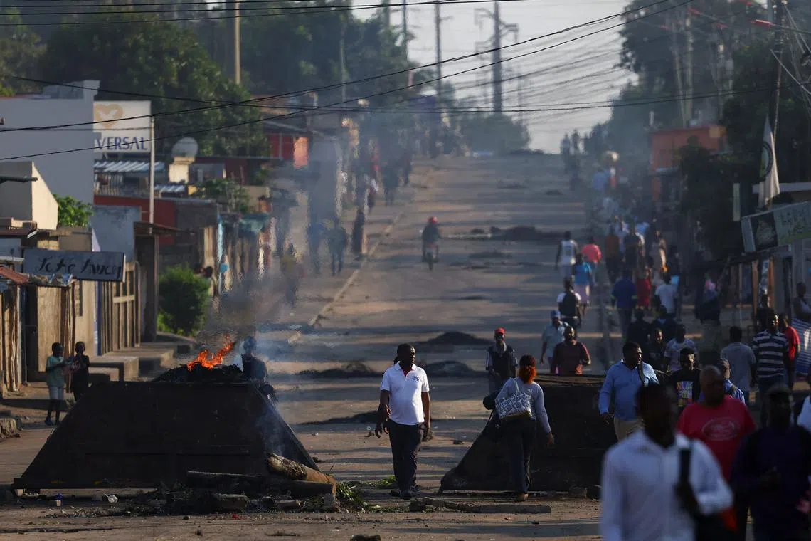 Locals walk past barricades that were used by protesters after the ruling Frelimo party was declared the winner of this month's disputed election, in Maputo, Mozambique, October 25, 2024. REUTERS/Siphiwe Sibeko/File Photo