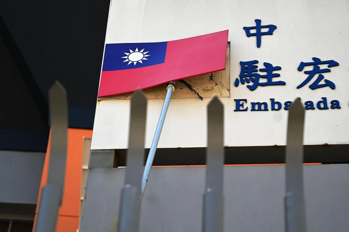 A worker takes down Taiwan's flag of the facade of the country's Embassy in Tegucigalpa on March 27, 2023. - China and Honduras announced the establishment of diplomatic relations on Sunday, a victory for Beijing that snatches a new ally from Taiwan, now recognized by only 13 countries in the world. (Photo by ORLANDO sierra / AFP)