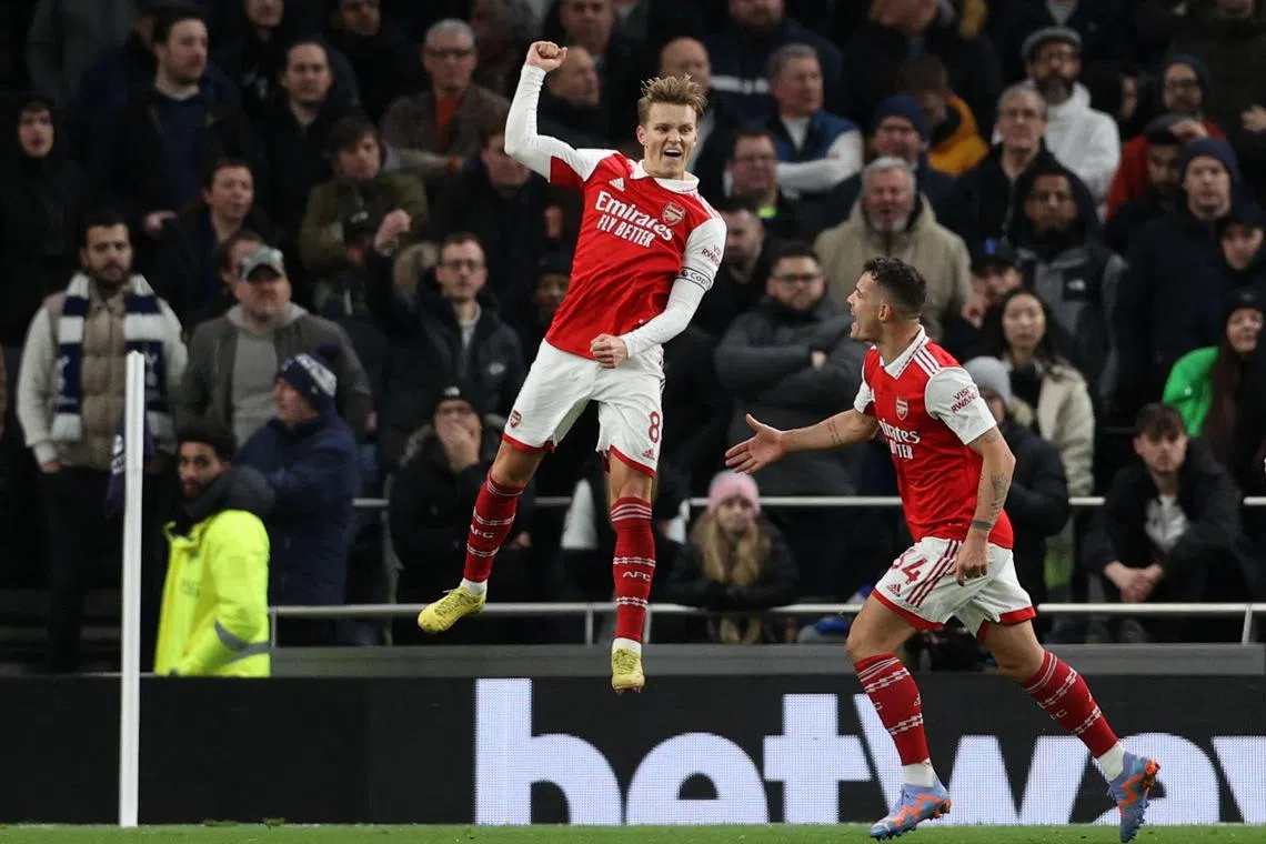 Arsenal's Norwegian midfielder Martin Odegaard (C) celebrates scoring the team's second goal during the English Premier League football match between Tottenham Hotspur and Arsenal at Tottenham Hotspur Stadium in London, on January 15, 2023. (Photo by ADRIAN DENNIS / AFP) / RESTRICTED TO EDITORIAL USE. No use with unauthorized audio, video, data, fixture lists, club/league logos or 'live' services. Online in-match use limited to 120 images. An additional 40 images may be used in extra time. No video emulation. Social media in-match use limited to 120 images. An additional 40 images may be used in extra time. No use in betting publications, games or single club/league/player publications. / 