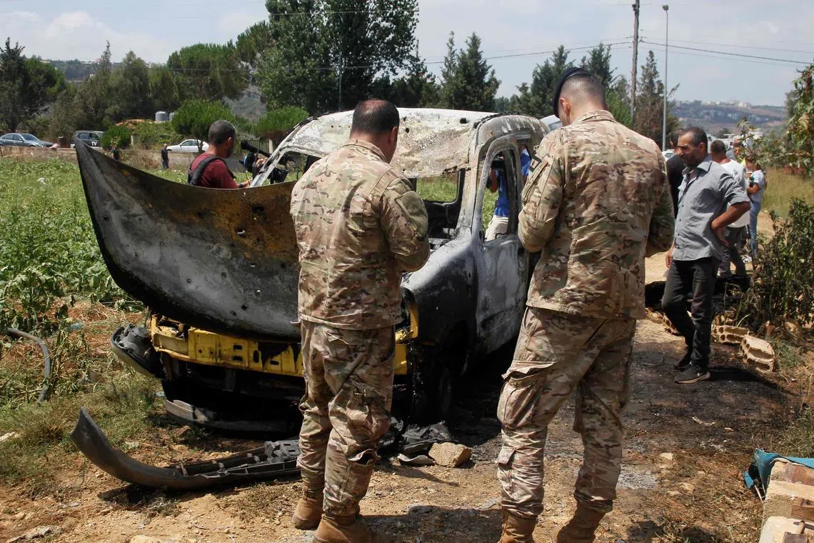Lebanese army soldiers checking the wreckage of a vehicle after Israel struck targets in Lebanon on July 20.