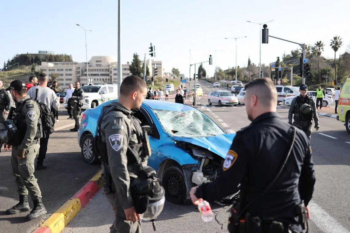A blue sedan collided with a lamppost next to a bus stop, hitting several people.