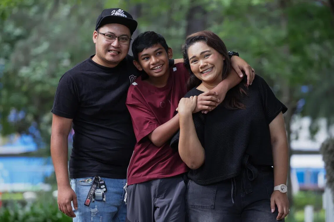 Aniq with his father, Muhammad Ismail (left) and his mother, Nur Umairah, who accompany him for every NDP rehearsal.