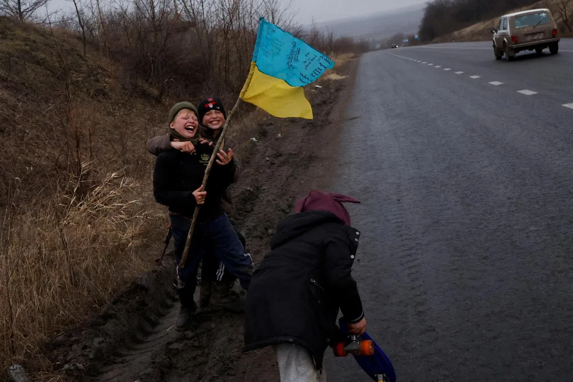 Children play by the side of a road, in Bakhmut, Ukraine, on Jan 5, 2023.