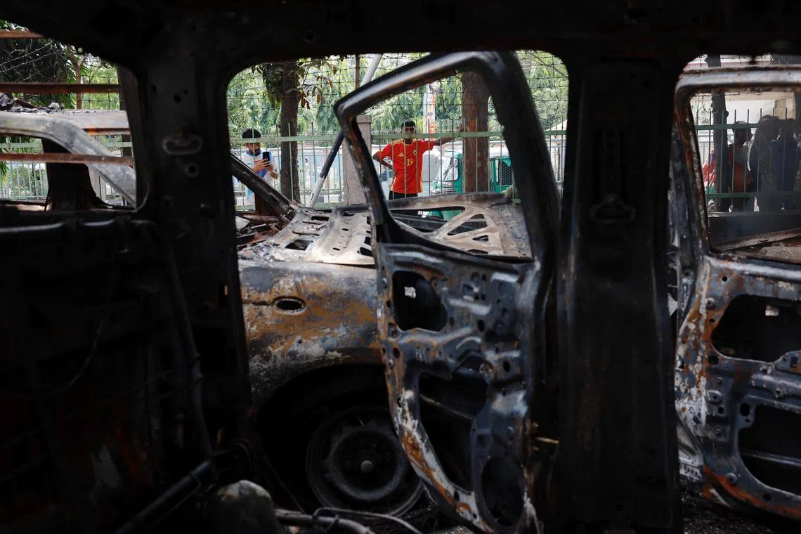 FILE PHOTO: People stand near vandalised cars at the Mohammadpur Police Station, after the resignation of Bangladeshi Prime Minister Sheikh Hasina, in Dhaka, Bangladesh, August 6, 2024. REUTERS/Mohammad Ponir Hossain/File Photo