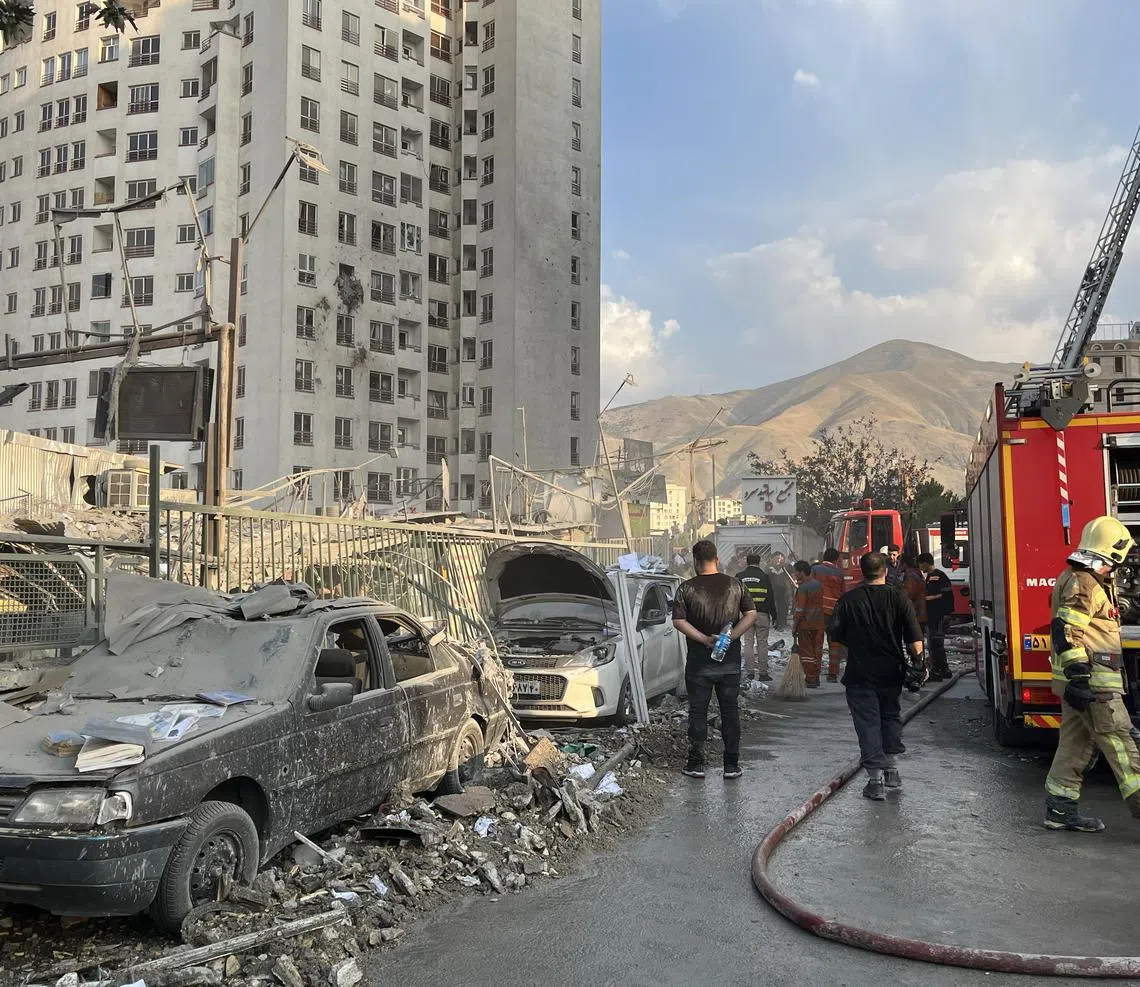 epa12172720 Fire fighters work outside a building that was hit by Israeli air strikes north of Tehran, Iran, 13 June 2025. Israel confirms it has launched strikes on Iran's 'nuclear program' as blasts are heard across the country. The strikes are part of Operation Rising Lion, Israel's Prime Minister Benjamin Netanyahu said, adding Iran was a threat to "Israel's very survival".  EPA-EFE/ABEDIN TAHERKENAREH