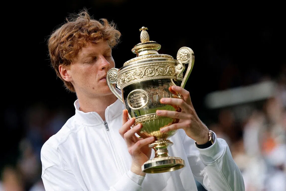 FILE PHOTO: Italy's Jannik Sinner celebrates with the trophy after winning the Wimbledon men's final against Spain's Carlos Alcaraz in London, July 13, 2025. REUTERS/Stephanie Lecocq/File Photo