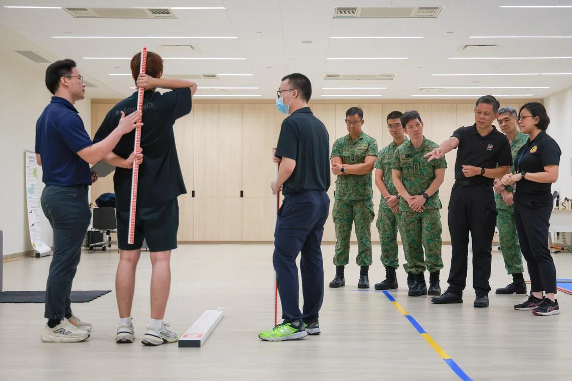 Minister for Defence Chan Chun Sing (third from right) observing a pre-enlistee undergoing a medical assessment at the regional health hub on April 13.