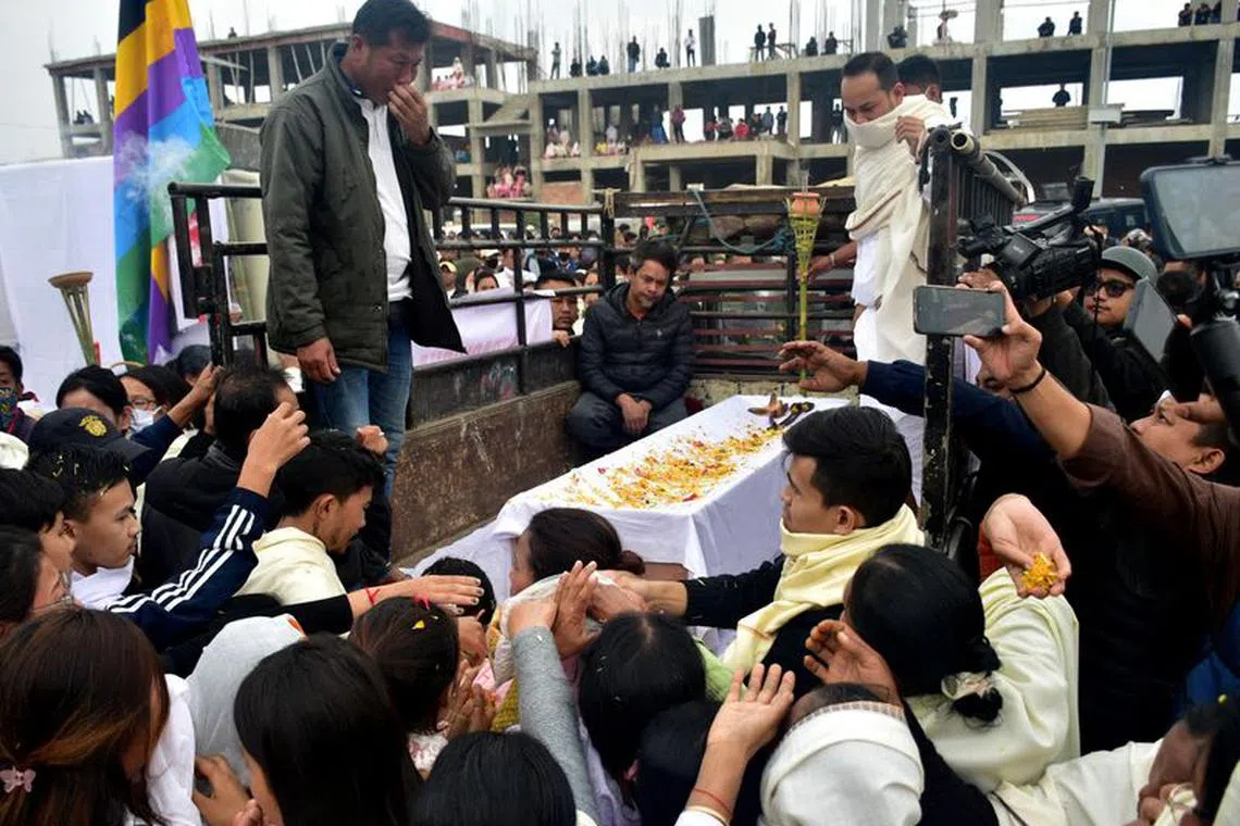 People gather around the body of a man, who according to police was killed during a gunfight between two unknown militant groups in a village in Manipur's Tengnoupal district, outside a hospital morgue in Imphal, India, December 5, 2023. REUTERS/Stringer/File Photo
