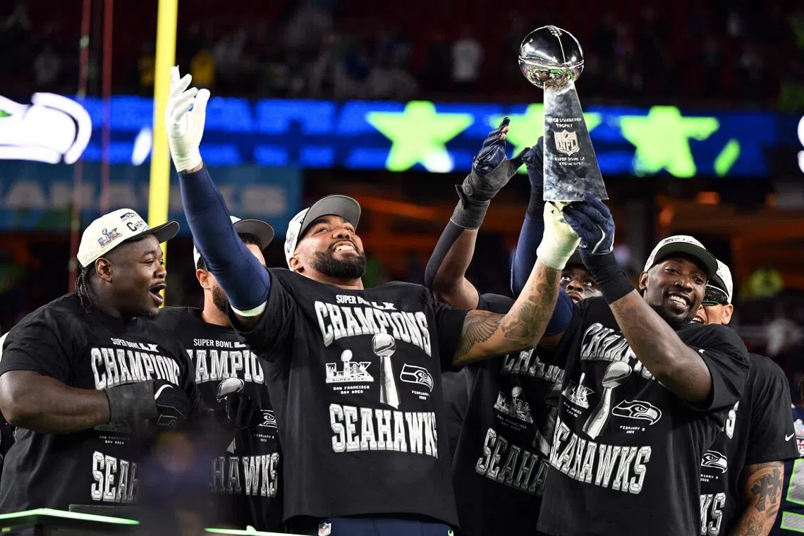 Seattle Seahawks' players celebrate with the Vince Lombardi Trophy after defeating the New England Patriots during Super Bowl LX at Levi's Stadium in Santa Clara, California.