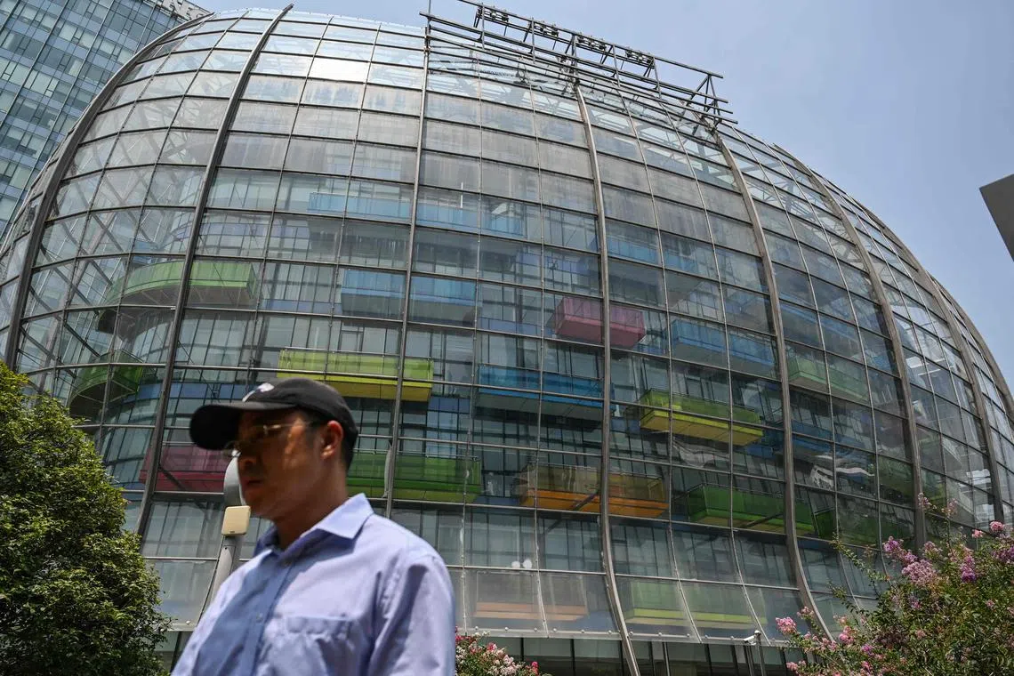 (FILES) This file photo taken on July 27, 2022 shows removed company signage (top) in a view of the unoccupied Evergrande Centre building in Shanghai. - After years of explosive growth Chinese authorities launched a crackdown on excessive debt in 2020, squeezing financing options for property sector giants such as Evergrande as they struggled to make repayments and restructure mountains of debt. Now they are facing mortgage boycotts and government pressure to deliver pre-sold homes. (Photo by Hector RETAMAL / AFP) / TO GO WITH CHINA-ECONOMY-PROPERTY-MORTGAGE,FOCUS BY BEIYI SEOW