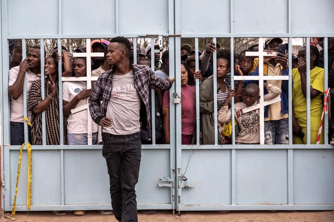 Onlookers reacting next to the scene where a Kenyan medical plane crashed, killing at least 6 people, on the outskirts of Nairobi, on Aug 7, 2025. 