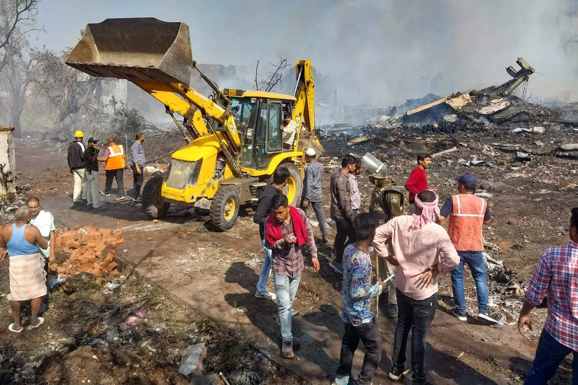 Rescue personnel and local residents gather near a firecracker plant following an explosion at Harda town in India's Madhya Pradesh state.