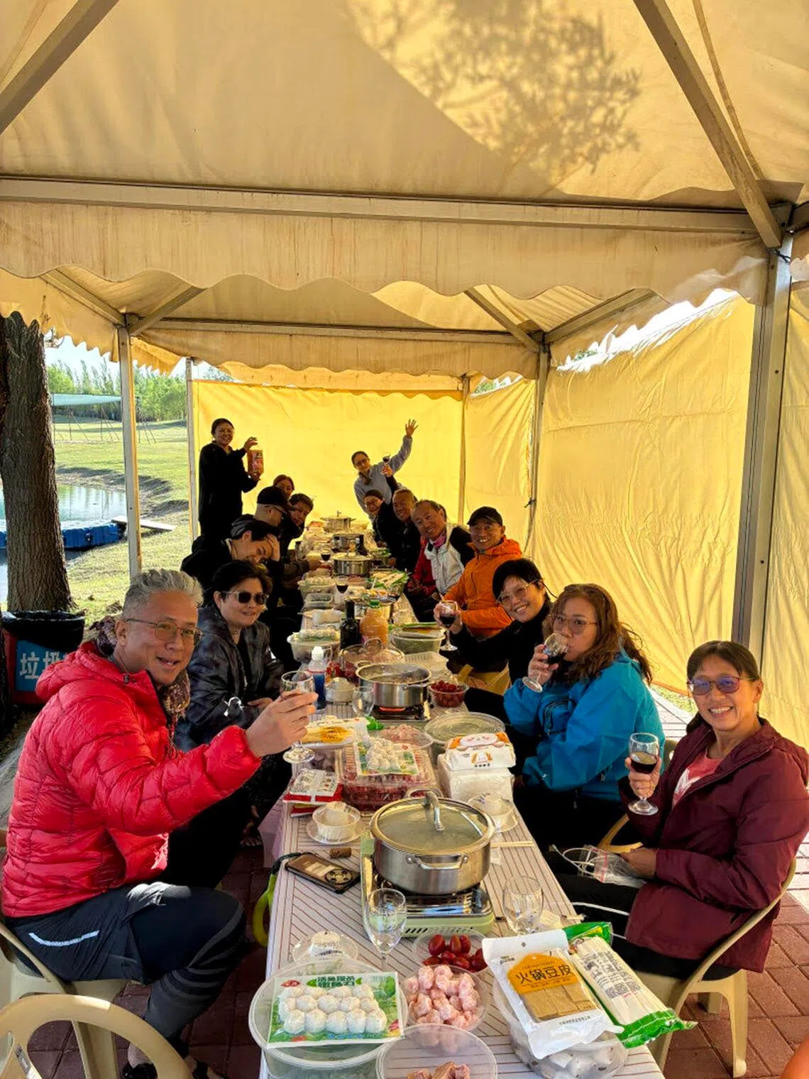 Rich Liow (extreme left in red jacket) and his fellow adventurers tucking into a steamboat dinner during the kayaking segment of their Gobi Desert trip.