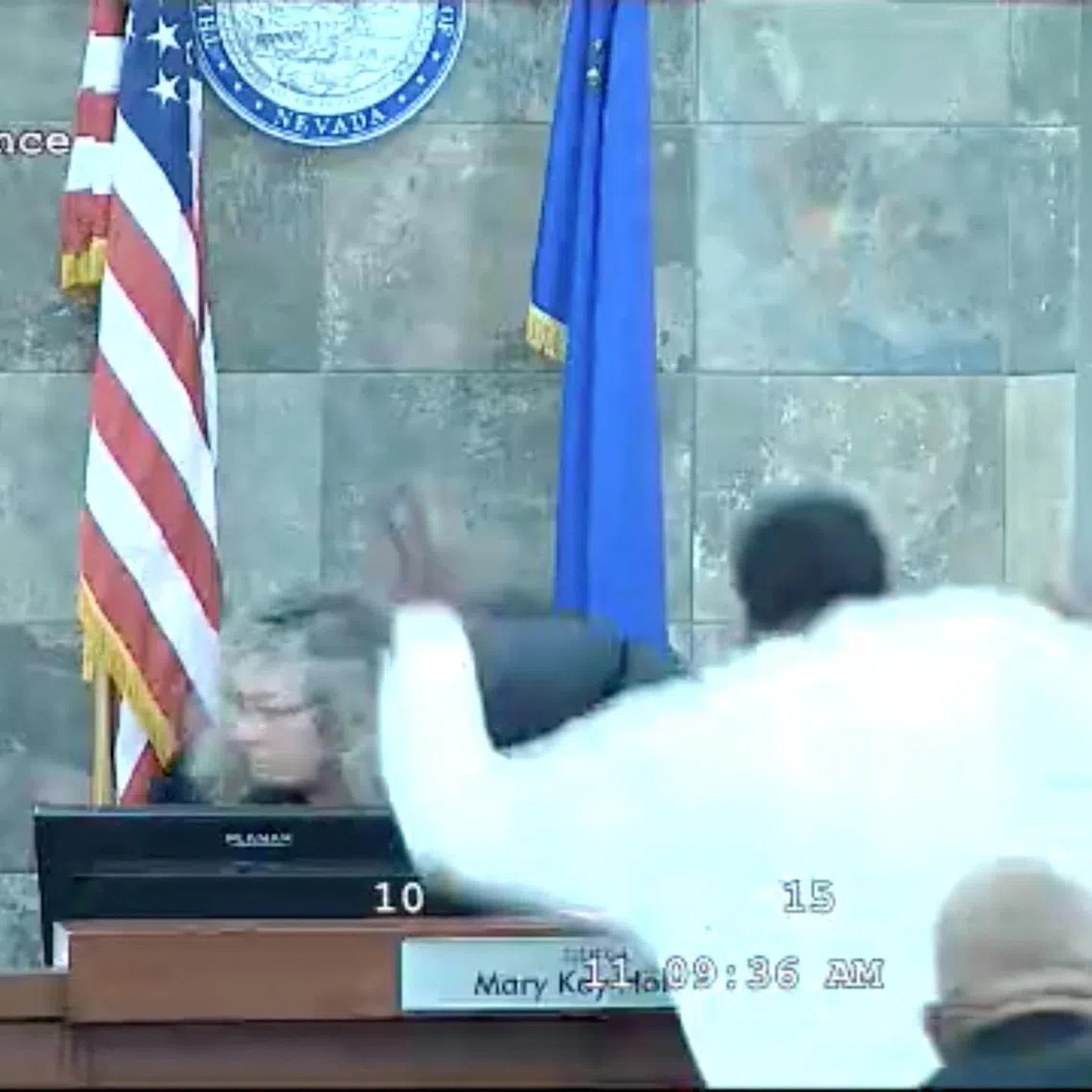 A still frame from a court video shows Redden jumping over a courtroom bench and attacking Judge Holthus.