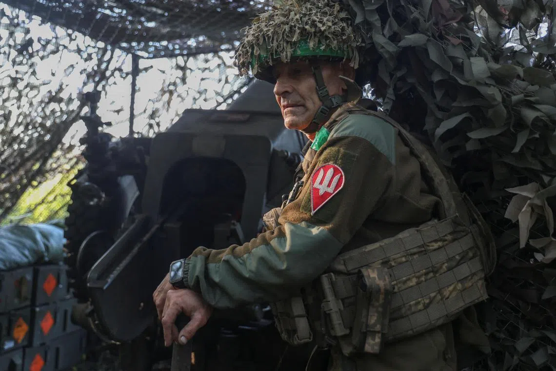 A Ukrainian serviceman preparing to fire a howitzer towards Russian troops, in Ukraine's Donetsk region, on Aug 5.