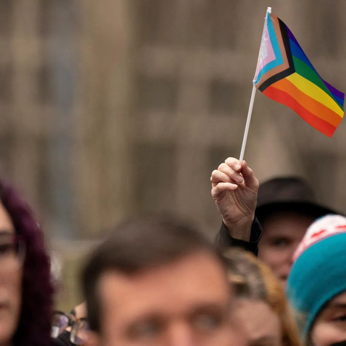 FILE PHOTO: A supporter holds a Pride flag in Seattle, Washington, U.S., February 14, 2025.  REUTERS/David Ryder/File Photo