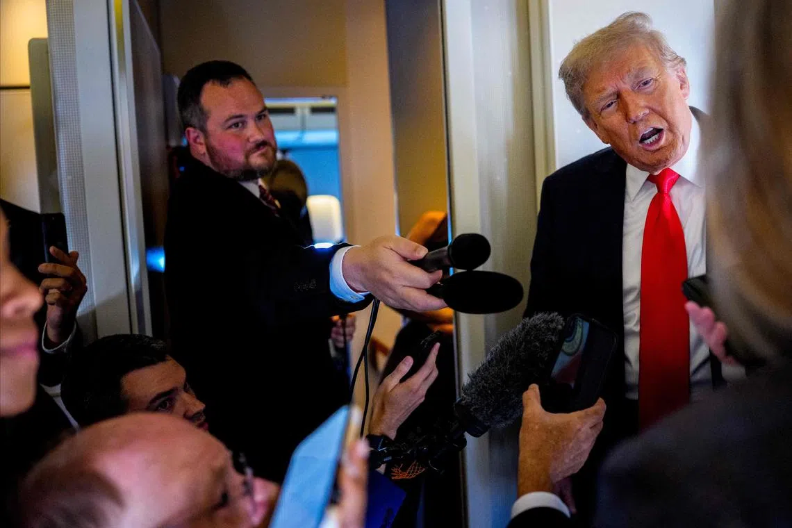 US President Donald Trump speaking to members of the media aboard Air Force One on Aug 15, en route to Anchorage, Alaska.
