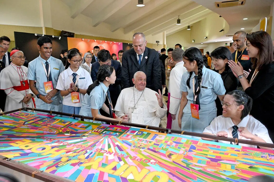 Pope Francis completing a Batik painting with students from Catholic Junior College, on his final day of his state visit to Singapore, on Sept 13, 2024.