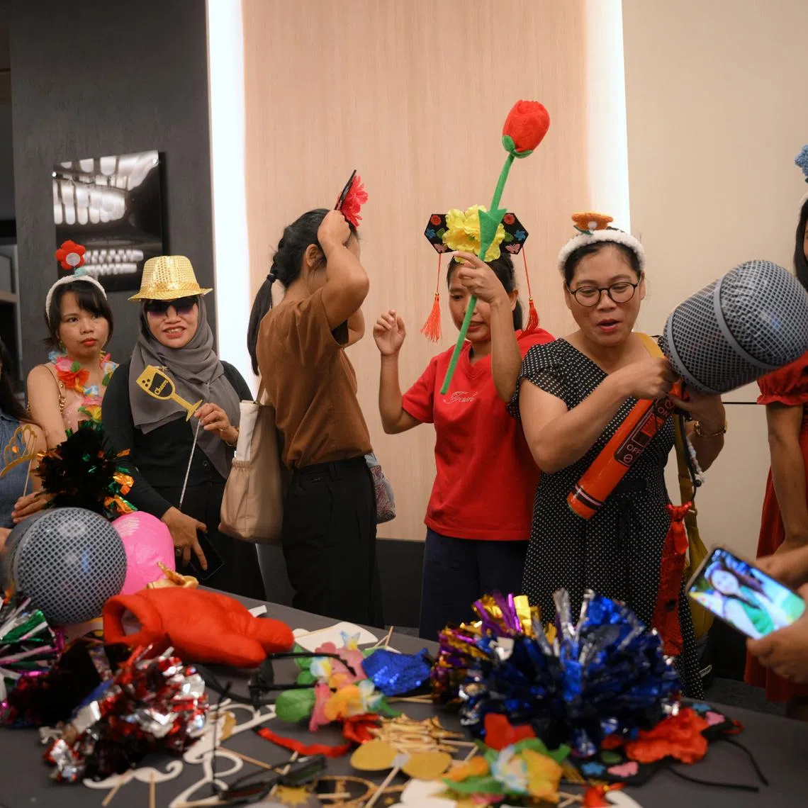Domestic workers dress up to have a picture taken at a Photo Booth during the May Day Domestic Employees Celebration held at Resorts World Convention Centre on June 21.