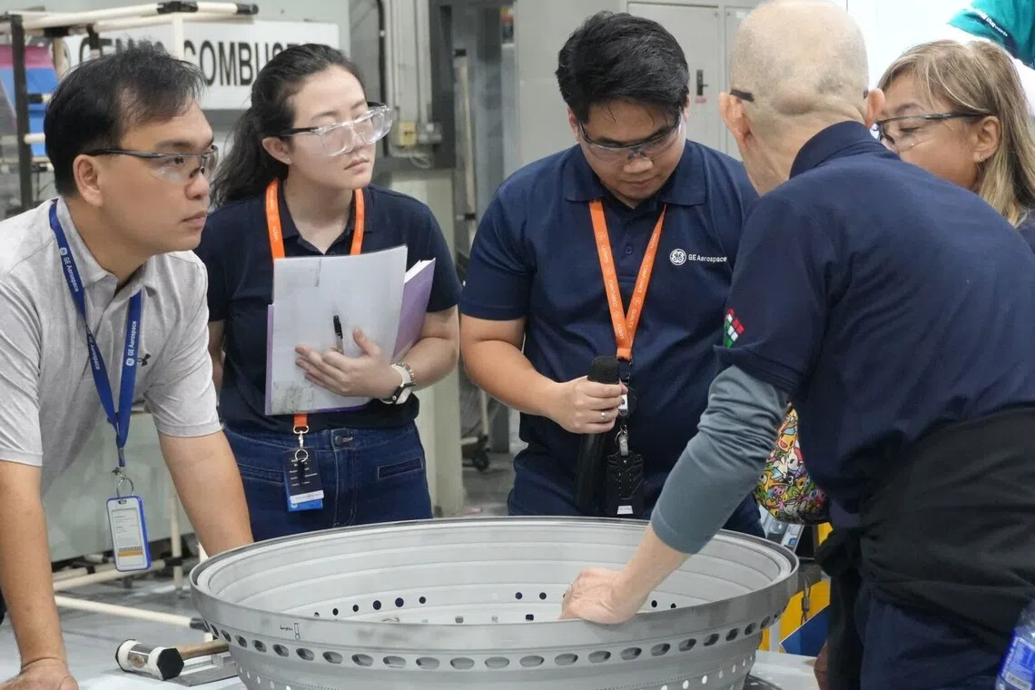 Ms Lim Jia Ying (second from left) collaborates with colleagues at GE Aerospace, where she works on streamlining processes and solving problems to improve safety in engine maintenance and repair.