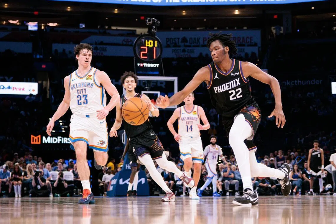 CJ Huntley of the Phoenix Suns goes after a loose ball in front of Brooks Barnhizer of the Oklahoma City Thunder during the second half at Paycom Center on April 12.