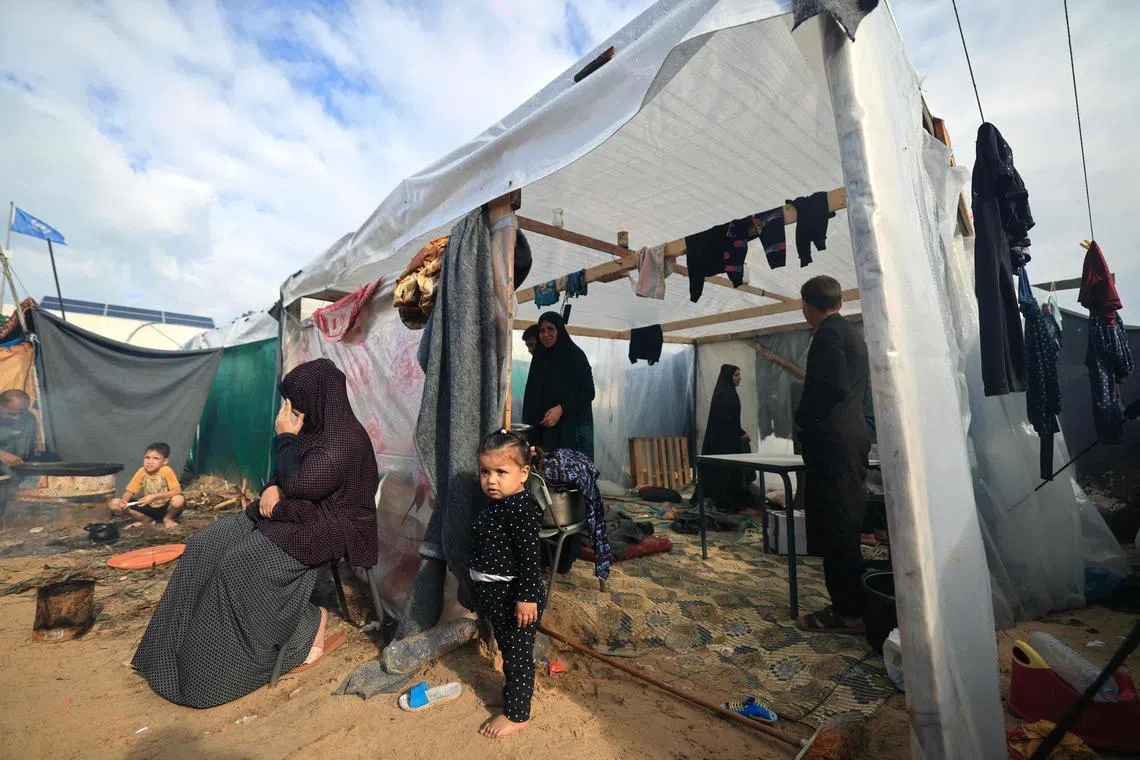 An Internally displaced Palestinian family, who fled from the Israeli bombardment of the northern Gaza Strip and now living in a make shift shelter, air their shelter following overnight rainstorms in Khan Yunis, in the southern Gaza Strip on November 15 , 2023, amid the ongoing battles between Israel and the Palestinian group Hamas. The war between Israel and Hamas has displaced almost 1.6 million Palestinians, according UNRWA, leaving hundreds of thousands living in cramped shelters with little food and insufficient water. More than 11,000 people have been killed in relentless Israeli bombardment of the Gaza Strip, according to the Hamas-run health ministry, since the war erupted after Palestinian militants raided southern Israel on October 7 killing at least 1200 people, according to official Israeli figures. (Photo by Mahmud HAMS / AFP)