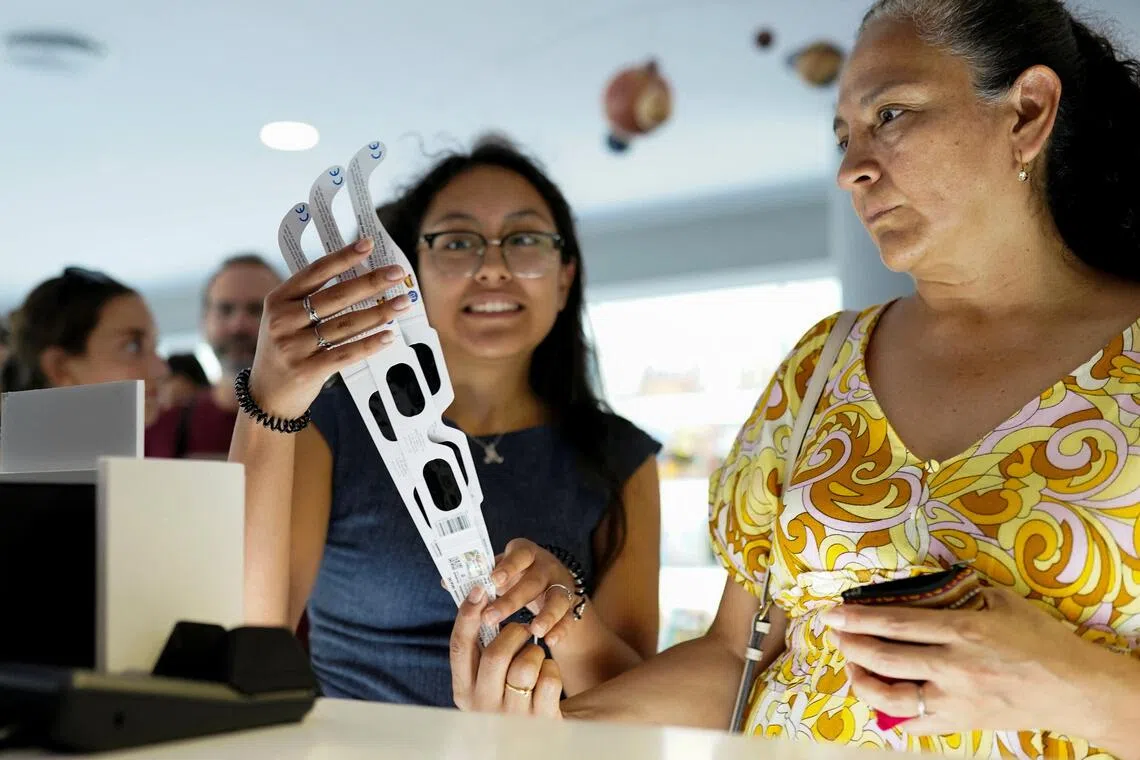 A lucky buyer manages to snag a pair of eclipse-viewing glasses at a store at Madrid’s planetarium.