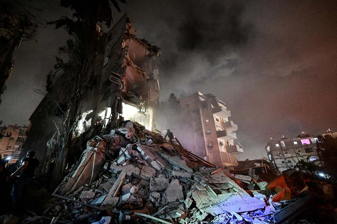 Rescue personnel working at the site of a residential building following a missile attack from Iran on Israel, at central Israel, June 15, 2025. 