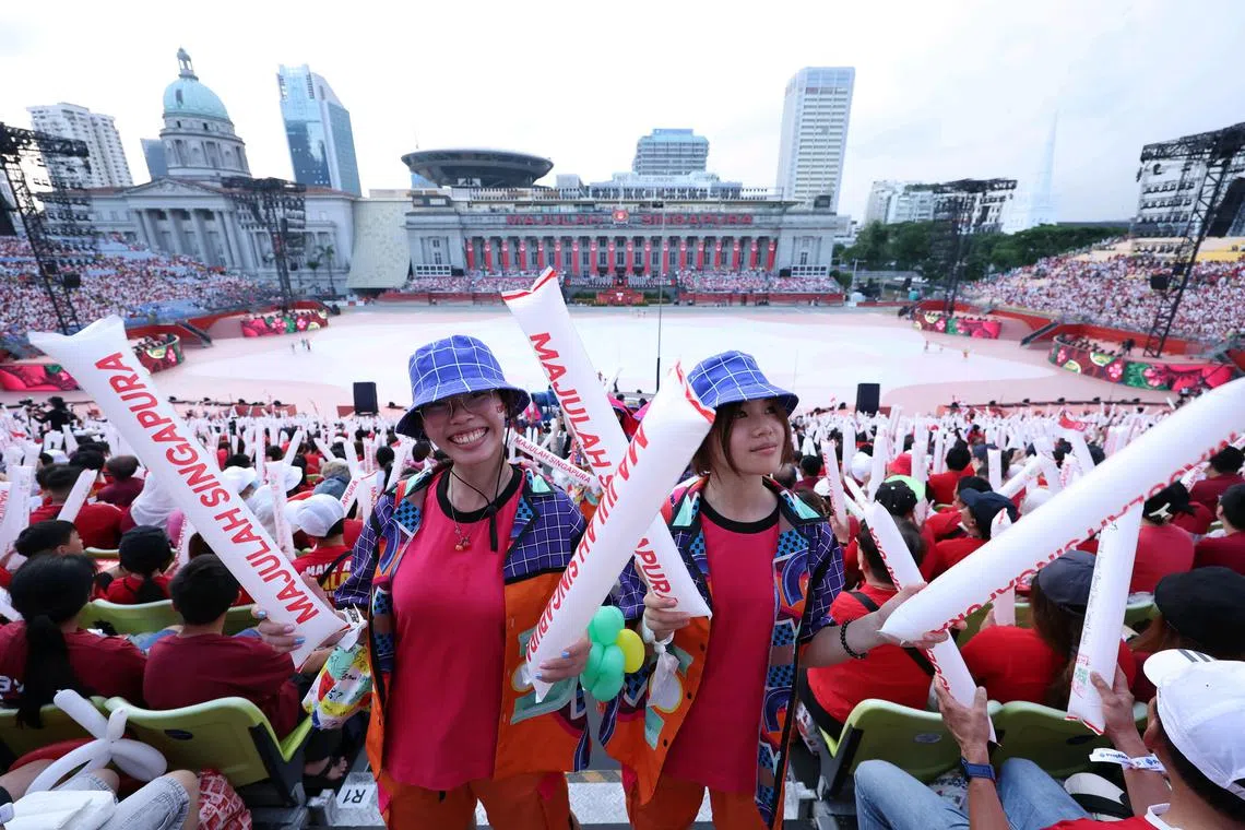 ST20250809_202515600544/pixndp2025/Brian Teo/Volunteers cheering during the National Day Parade at the Padang on Aug 9, 2025. ST PHOTO: BRIAN TEO