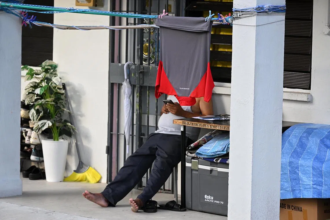 Generic photo of a man using his mobile phone while a polo t-shirt is hung out to dry at 45 Stirling Road on March 6, 2025.