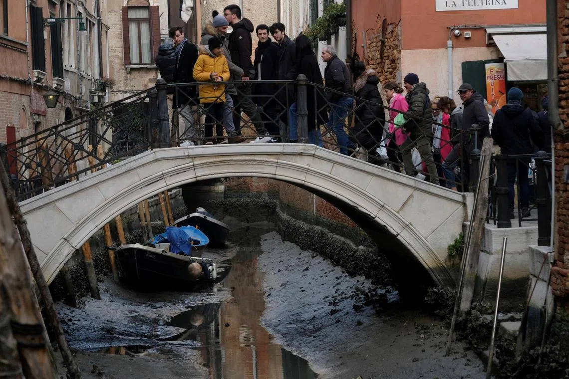 Boats are pictured in a canal during a severe low tide in the lagoon city of Venice, Italy, February 17, 202. REUTERS/Manuel Silvestri