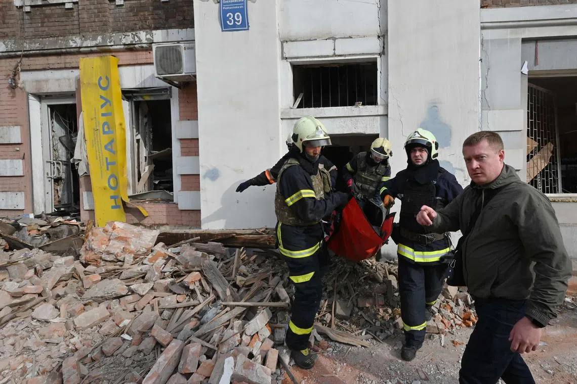 Rescuers remove the body of a deceased elderly woman from the rubble of a residential building destroyed by a Russian missile strike, in Kharkiv, Ukraine.