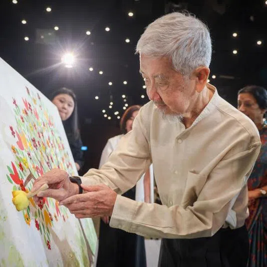  Dr Leong Sai Fan putting the finishing touches on "Where Life Takes Root And Hope Blooms", a collective art tribute at The National University Centre for Organ Transplantation on March 27. 