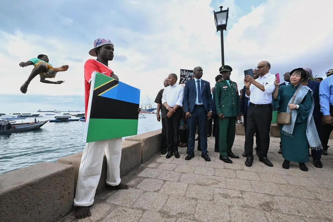 President Tharman Shanmugaratnam and his spouse Jane Ittogi Shanmugaratnam filming a group of locals who welcomed them by diving into the sea in Stone Town in Zanzibar, Tanzania, on June 10.