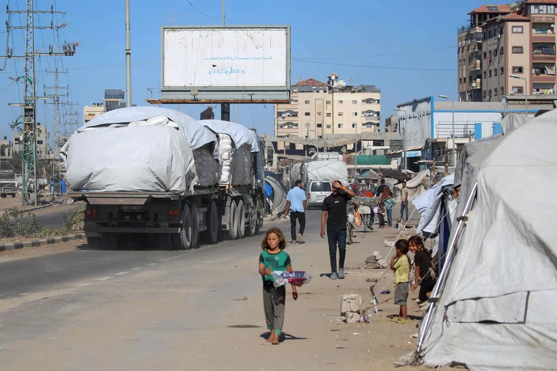 Trucks carrying aid enter Gaza through the Karm Abu Salem crossing in the central Gaza Strip, on Oct 14.