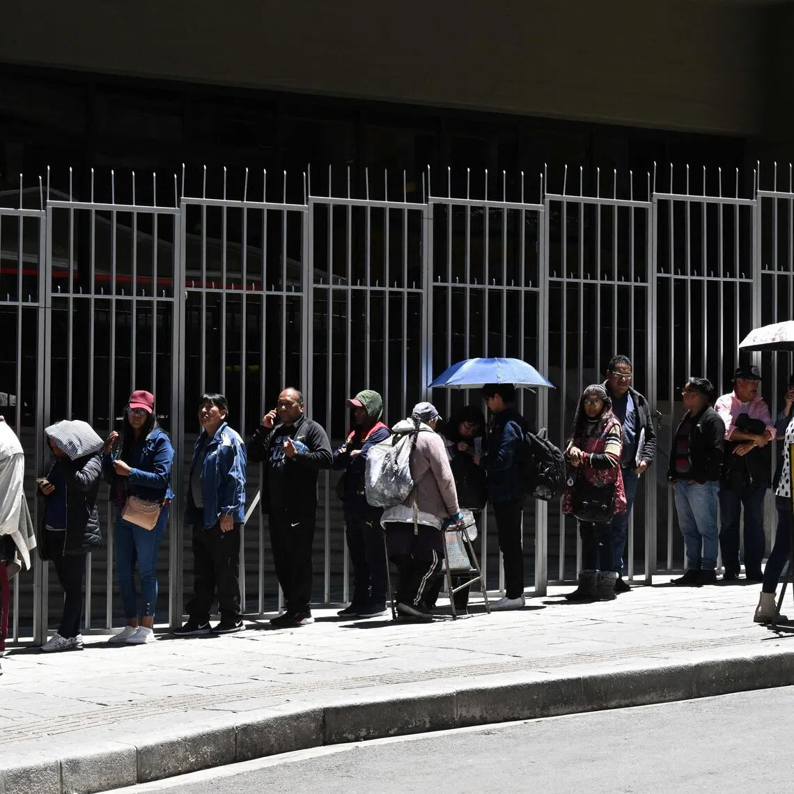 People queue at the Central Bank of Bolivia in La Paz to exchange their "B" series banknotes after the government temporarily invalidated them following the Feb 27 air accident at El Alto airport.