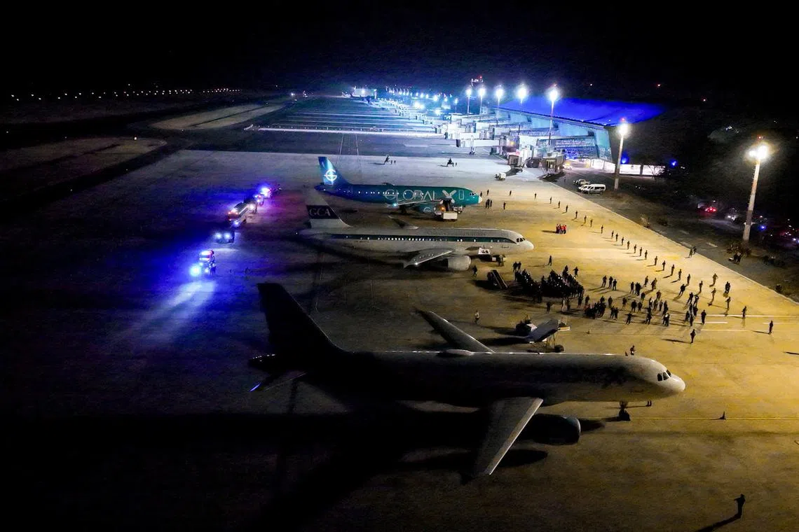 Salvadoran police officers escort alleged members of the Venezuelan gang Tren de Aragua recently deported by the U.S. government to be imprisoned in the Terrorism Confinement Center (CECOT) prison, as part of an agreement with the Salvadoran government, at the El Salvador International Airport in San Luis Talpa, El Salvador, in this handout image obtained March 16, 2025. Secretaria de Prensa de la Presidencia/Handout via REUTERS/ File Photo