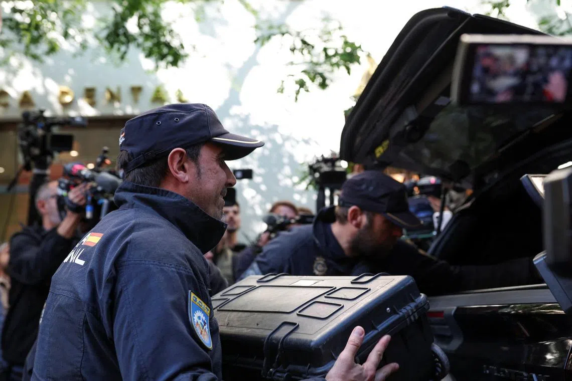 Police officers pack cases into their car outside the office of former Spanish prime minister Jose Luis Rodriguez Zapatero, in Madrid on May 19. He is being investigated for alleged influence peddling and related crimes, and has been summoned to testify on June 2.