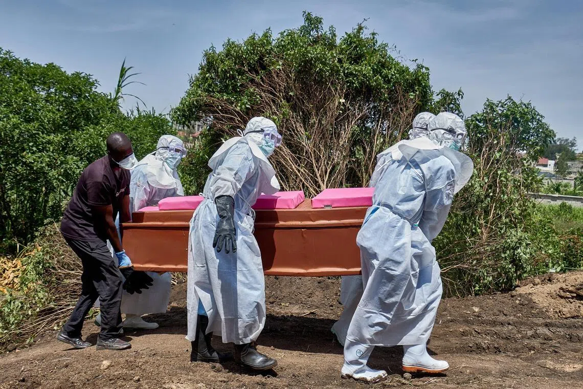 Red Cross workers wearing personal protective equipment (PPE) carry the coffin of a man who died of Ebola virus before his burial in Bunia, Ituri province, in the Democratic Republic of Congo, on June 10, 2026. 