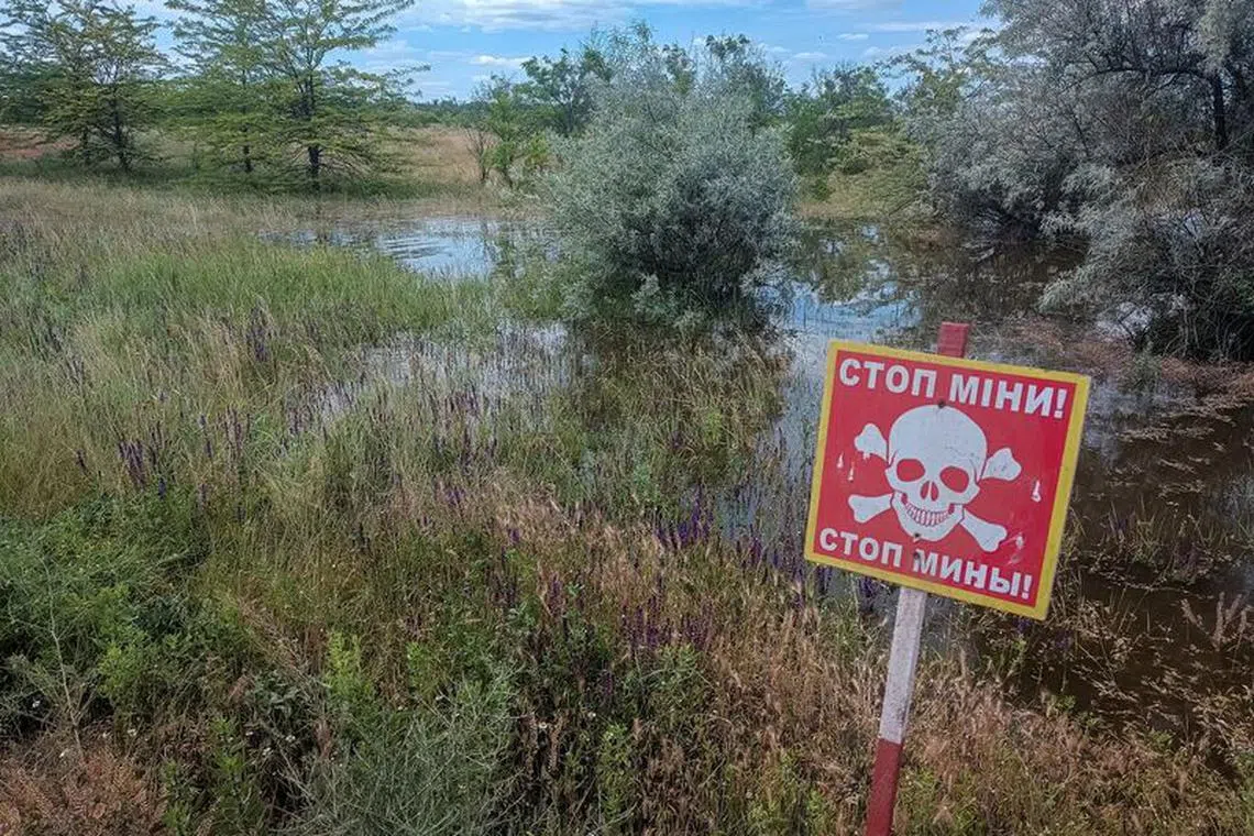 FILE PHOTO: A mine danger sign is seen near a flooded area after the Nova Kakhovka dam breached, amid Russia's attack on Ukraine, in the village of Snihurivka in Kherson region, Ukraine June 8, 2023. REUTERS/Viktoriia Lakezina/File photo