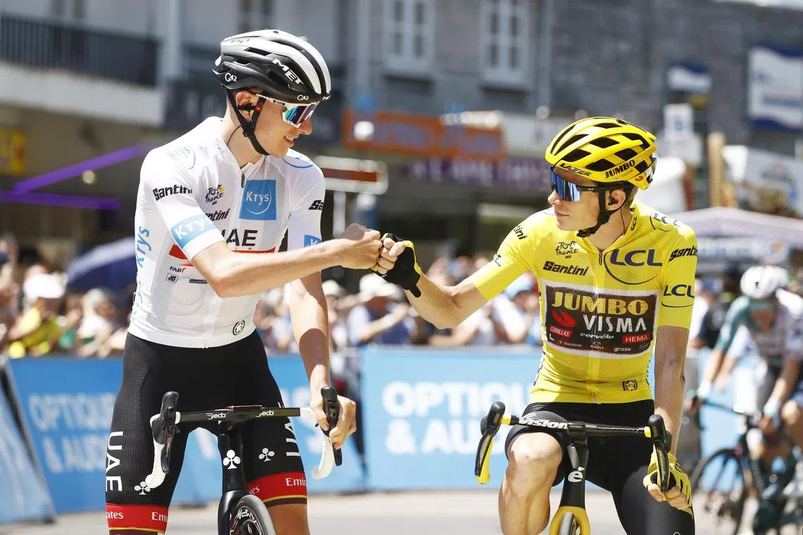 Slovenian rider Tadej Pogacar (left) of UAE Team Emirates bumps fists with the Yellow Jersey Danish rider Jonas Vingegaard of Jumbo Visma before the start of the 18th stage of the Tour de France 2022. 