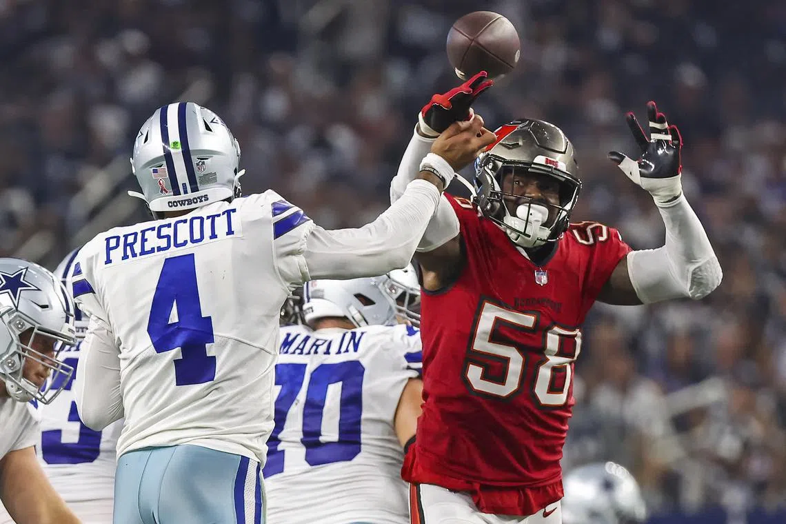 FILE PHOTO: Sep 11, 2022; Arlington, Texas, USA;  Dallas Cowboys quarterback Dak Prescott (4) hits his hand against Tampa Bay Buccaneers linebacker Shaquil Barrett (58) as he throws the ball during the fourth quarter at AT&T Stadium. Mandatory Credit: Kevin Jairaj-USA TODAY Sports/File Photo