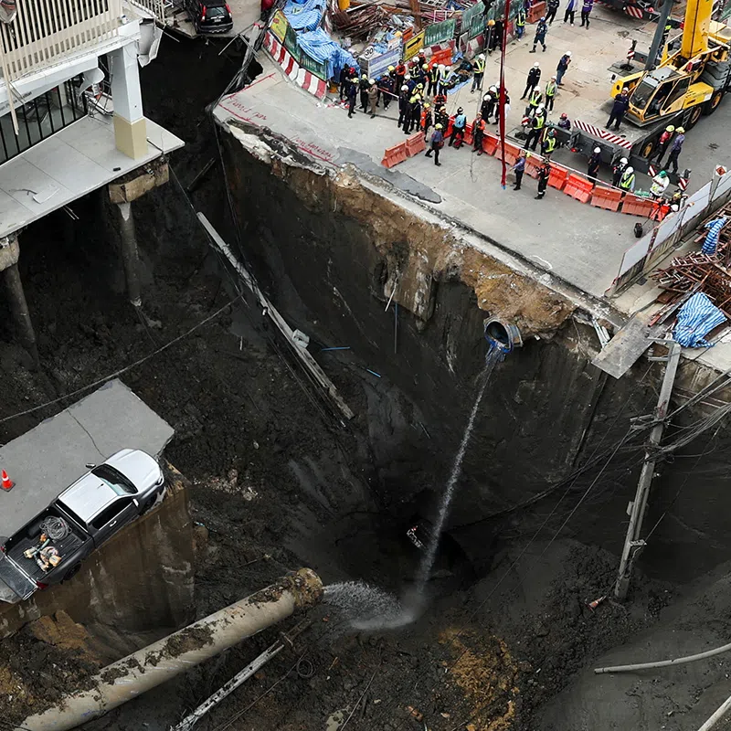 A vehicle teeters on the edge of a massive sinkhole that opened on Samsen Road near Vajira Hospital, in Bangkok, Thailand, September 24, 2025. REUTERS/Chalinee Thirasupa     TPX IMAGES OF THE DAY     
