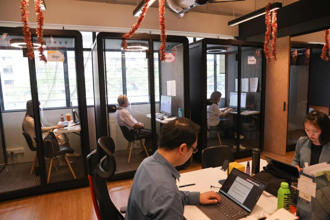 Helpline volunteers in helpline booths (background) tending to calls to Youthline.