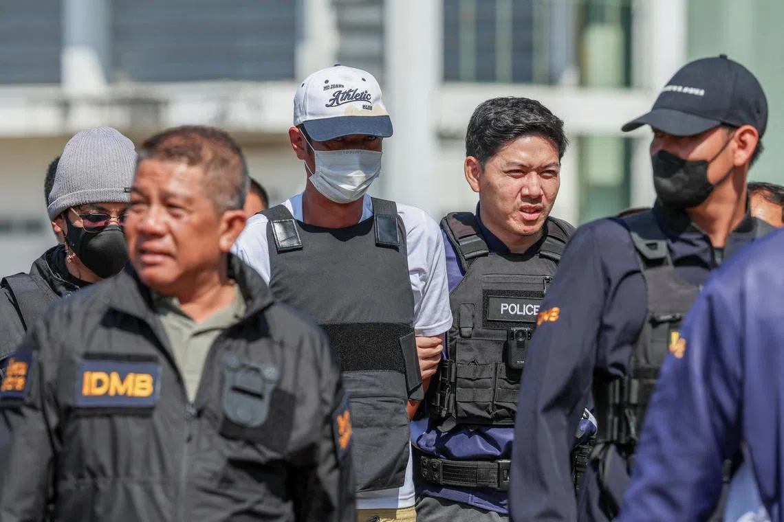 Ekkalak Paenoi, a suspect in the assassination of a former politician with now-dissolved Cambodia National Rescue Party (CNRP) Lim Kimya, 74, is escorted by police officers as he arrives in Thailand following handing over from Cambodia to Thai authorities, in Bangkok, Thailand on Jan 11, 2025. 