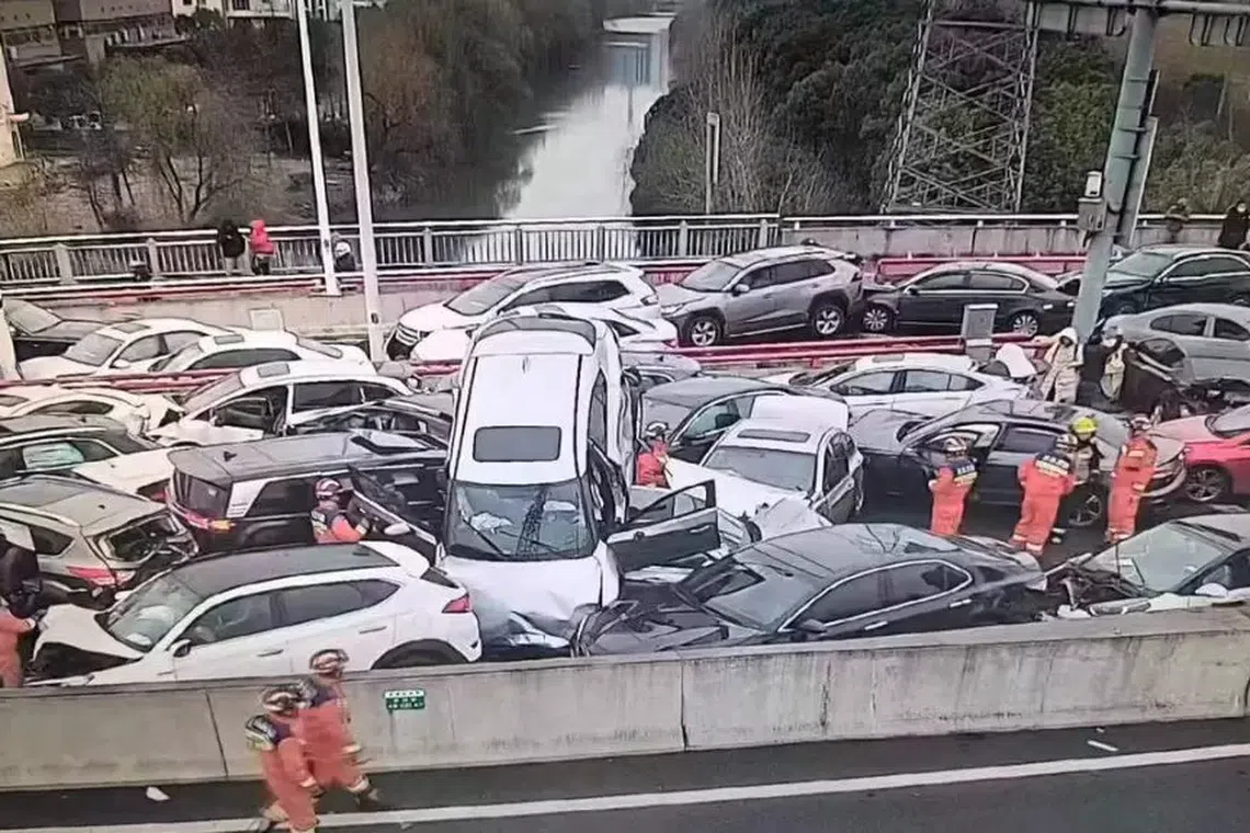 Numerous cars clumped together haphazardly on the highway with one jack-knifed at a severe angle in the air. 