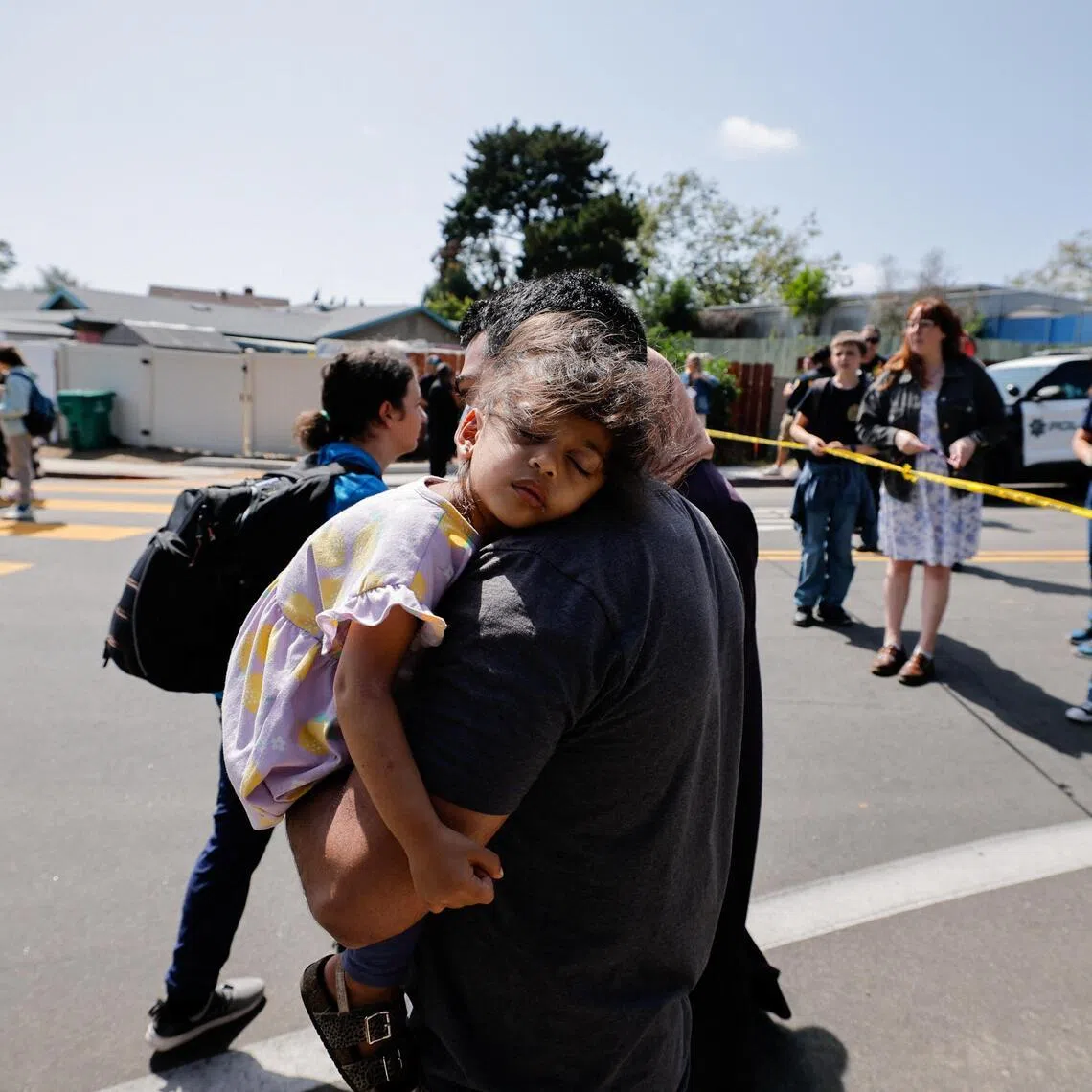 A parent carries his child while they leave the mosque, at the scene of a shooting at the Islamic Center in San Diego, California, on May 18.