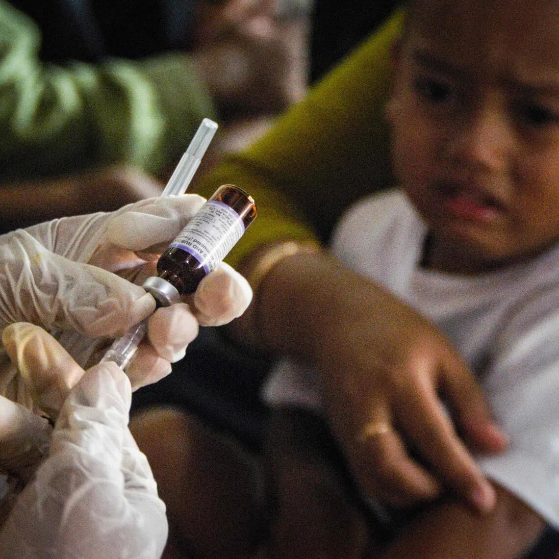 A health worker prepares a measles-rubella vaccine at an integrated community health post amid a measles outbreak due to low vaccination coverage in Cikukuk, West Java on April 6, 2026. (Photo by Timur Matahari / AFP)