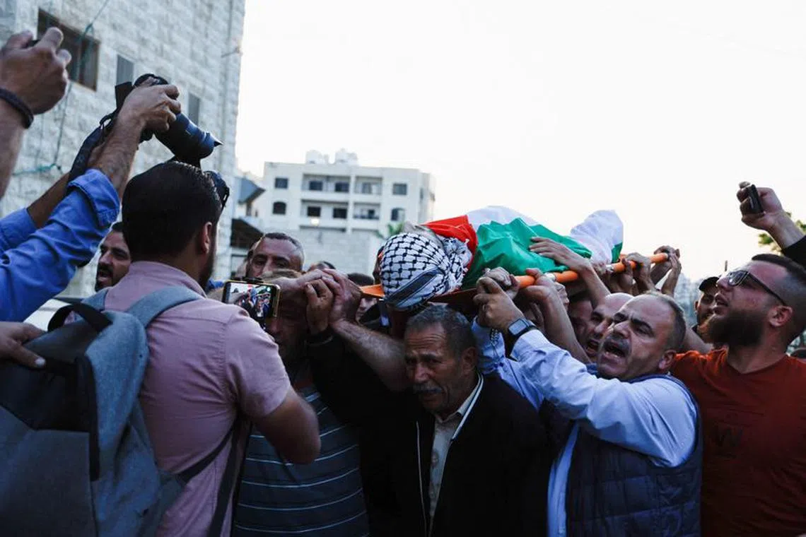 SENSITIVE MATERIAL. THIS IMAGE MAY OFFEND OR DISTURB    Mourners carry the body of Palestinian Moath Odeh, who was killed during clashes with Israeli settlers and security forces, in Nablus, in the Israeli-occupied West Bank, October 11,2023. REUTERS/Raneen Sawafta