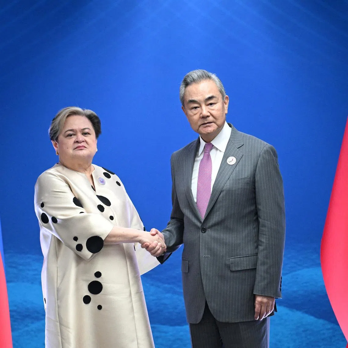 Philippine Foreign Secretary Theresa Lazaro shakes hands with China's Foreign Minister Wang Yi during their bilateral meeting on the sidelines of the Association of Southeast Asian Nations (ASEAN) Foreign Ministers' Meeting in Pasay, Metro Manila on July 22, 2026.     TED ALJIBE/Pool via REUTERS